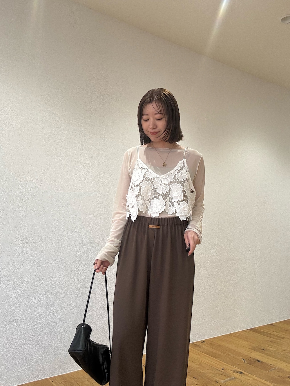 ホワイト系のシャツ/ブラウス、ブラウン系のスラックスを着用したレディースの夏コーディネートの2枚目の写真