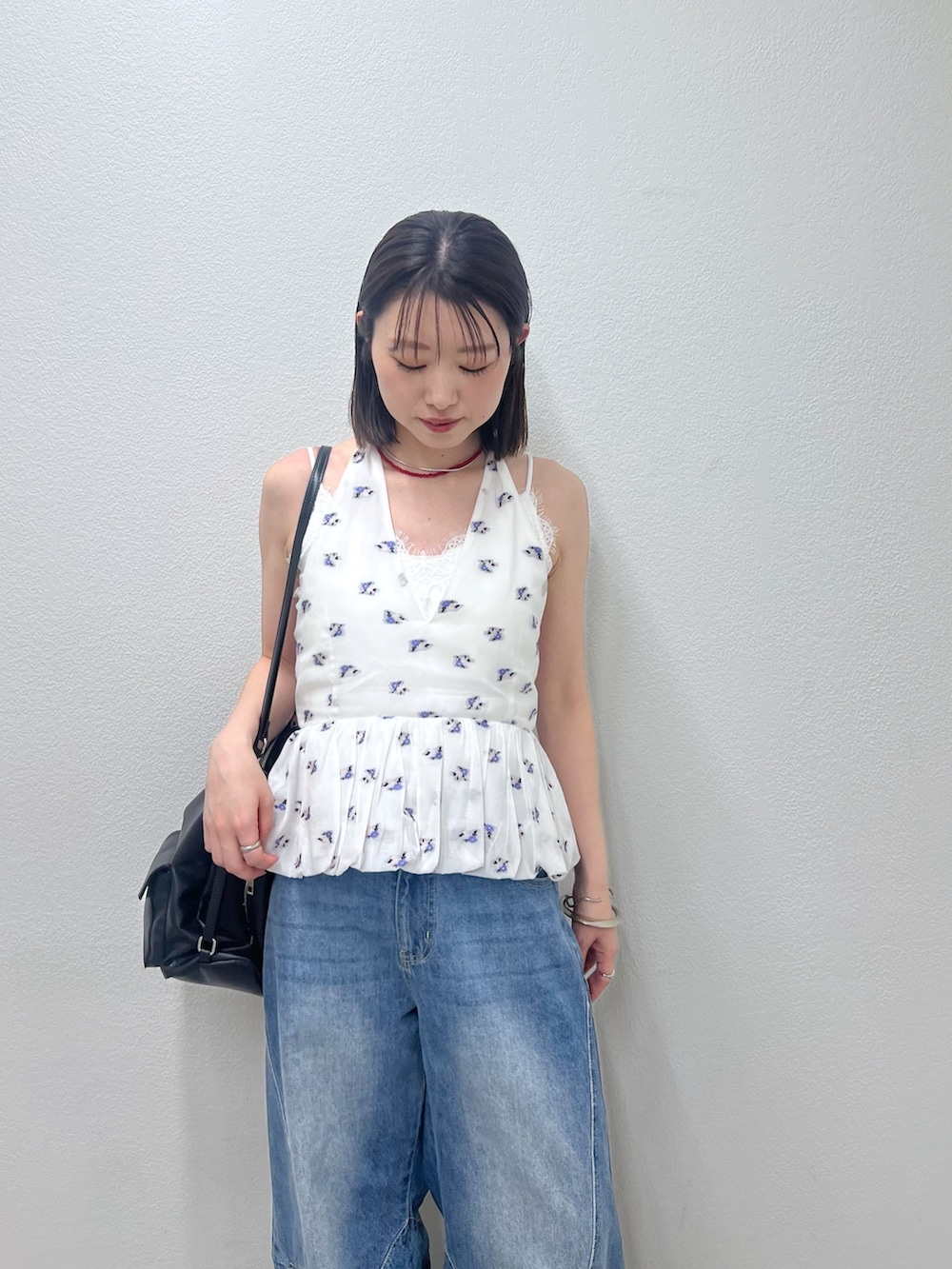 ブルー系のデニムパンツ、ホワイト系のシャツ/ブラウス、レッド系のネックレスを着用したレディースの春コーディネートの2枚目の写真