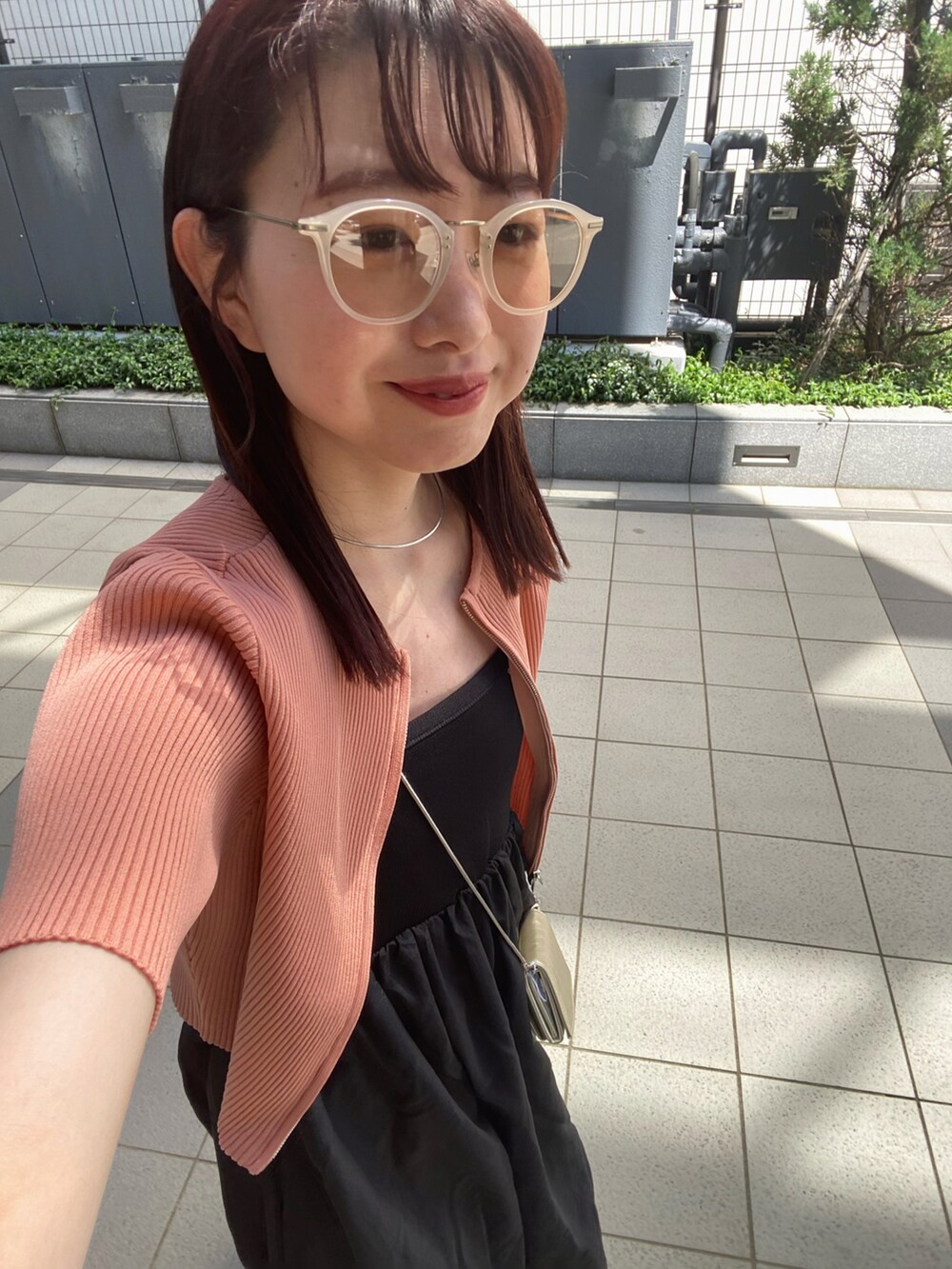 ブラック系のワンピース、オレンジ系のニット/セーターを着用したレディースの春コーディネートの3枚目の写真