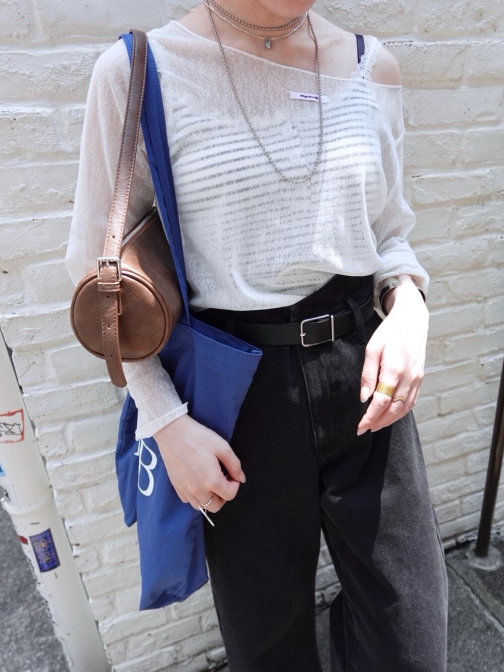 ホワイト系のTシャツ/カットソー、ブラック系のデニムパンツ、ホワイト系のキャミソールを着用したレディースの夏コーディネートの3枚目の写真