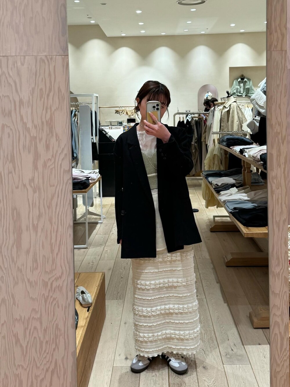 ブラック系のテーラードジャケット、グリーン系のシャツ/ブラウス、ホワイト系のスカートを着用したレディースの冬コーディネートの4枚目の写真