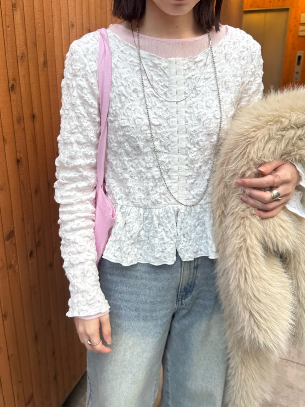 ベージュ系のその他アウター、ピンク系のトートバッグ、ブルー系のデニムパンツを着用したレディースの冬コーディネートの4枚目の写真