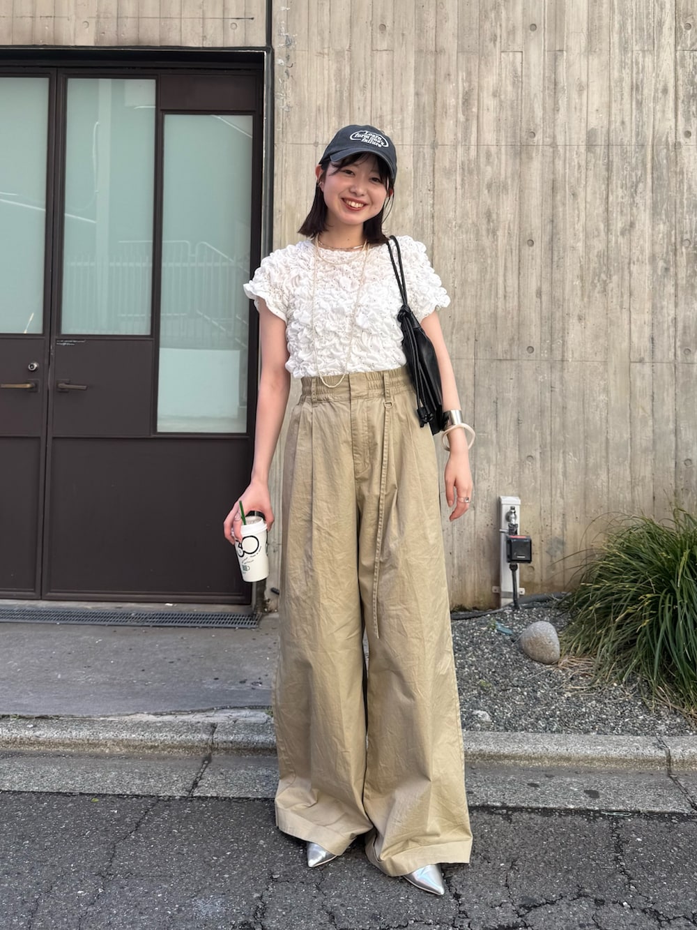 ホワイト系のTシャツ/カットソー、ベージュ系のその他パンツ、ブラック系のパンプスを着用したレディースの春コーディネートの2枚目の写真