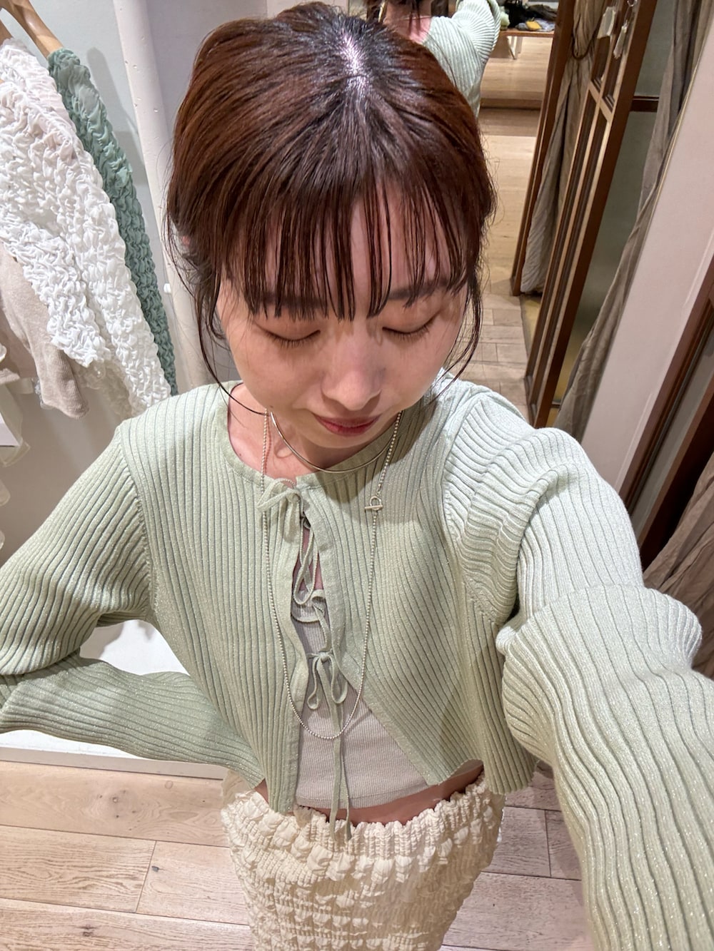 ホワイト系のスカート、グリーン系のカーディガン/ボレロを着用したレディースの冬コーディネートの2枚目の写真