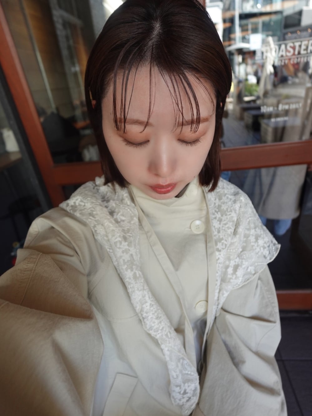 ホワイト系のトレンチコート、イエロー系のブーツを着用したレディースの冬コーディネートの5枚目の写真