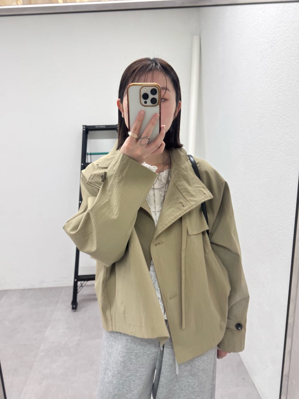 ホワイト系のトレンチコート、ホワイト系のシャツ/ブラウス、グレー系のスウェットパンツを着用したレディースの冬コーディネートの4枚目の写真