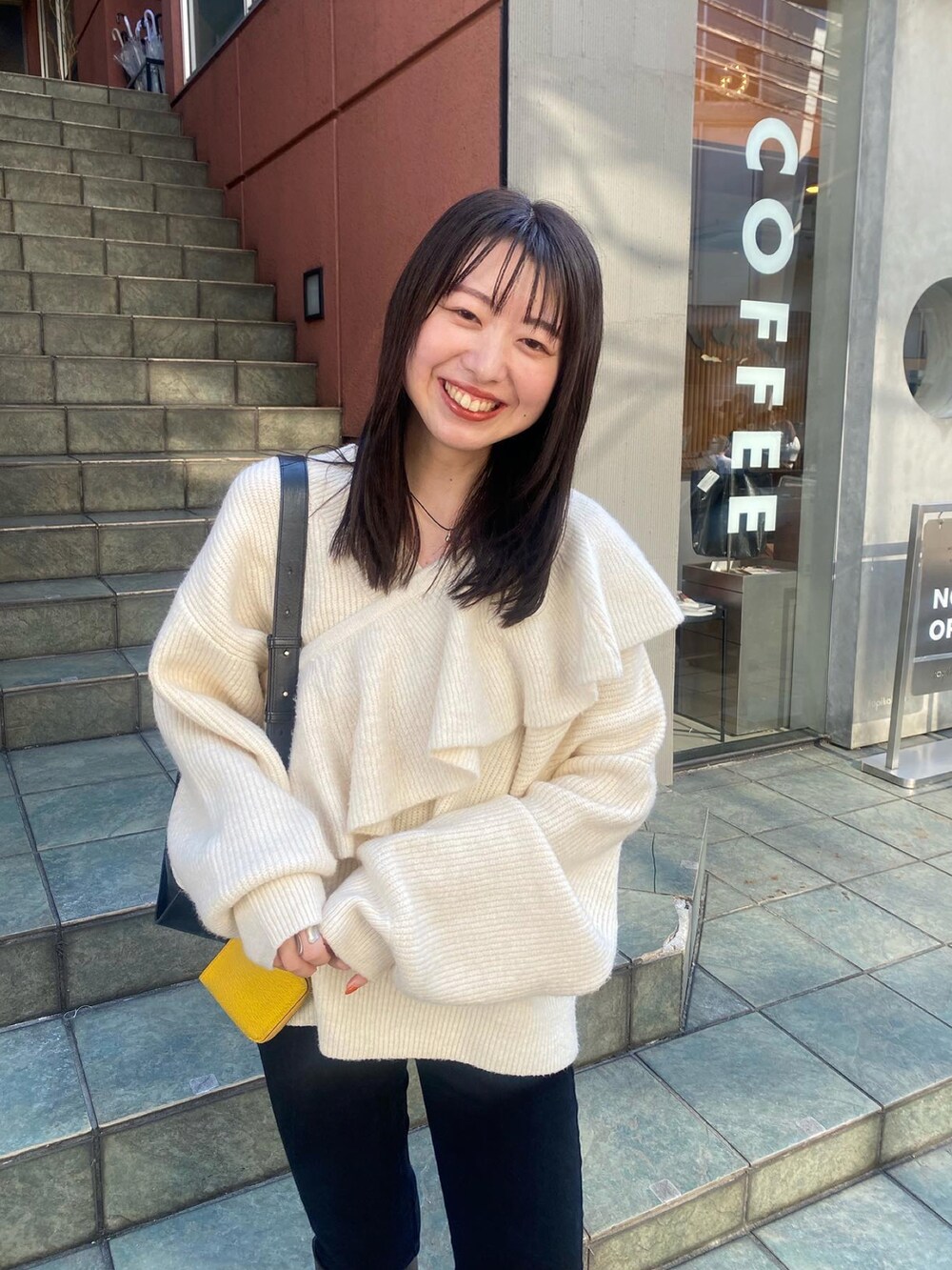 ホワイト系のニット/セーター、ブラック系のショルダーバッグを着用したレディースの冬コーディネートの3枚目の写真