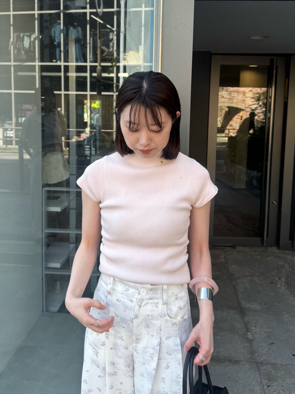 ピンク系のニット/セーター、ホワイト系のその他パンツを着用したレディースの春コーディネートの4枚目の写真