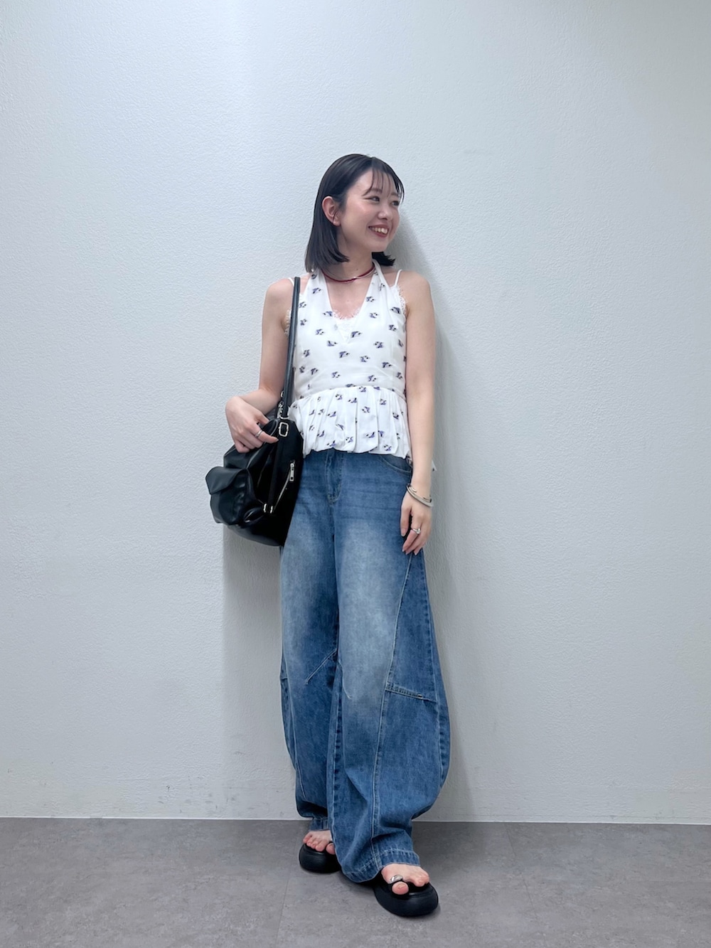 ブルー系のデニムパンツ、ホワイト系のシャツ/ブラウス、レッド系のネックレスを着用したレディースの春コーディネートの4枚目の写真