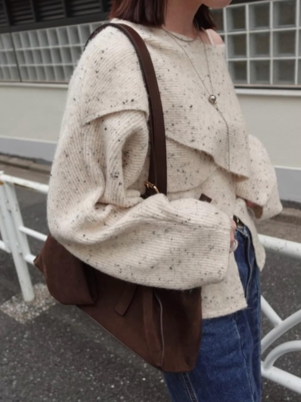 ホワイト系のニット/セーター、ブルー系のデニムパンツ、ブラウン系のトートバッグを着用したレディースの秋コーディネートの2枚目の写真
