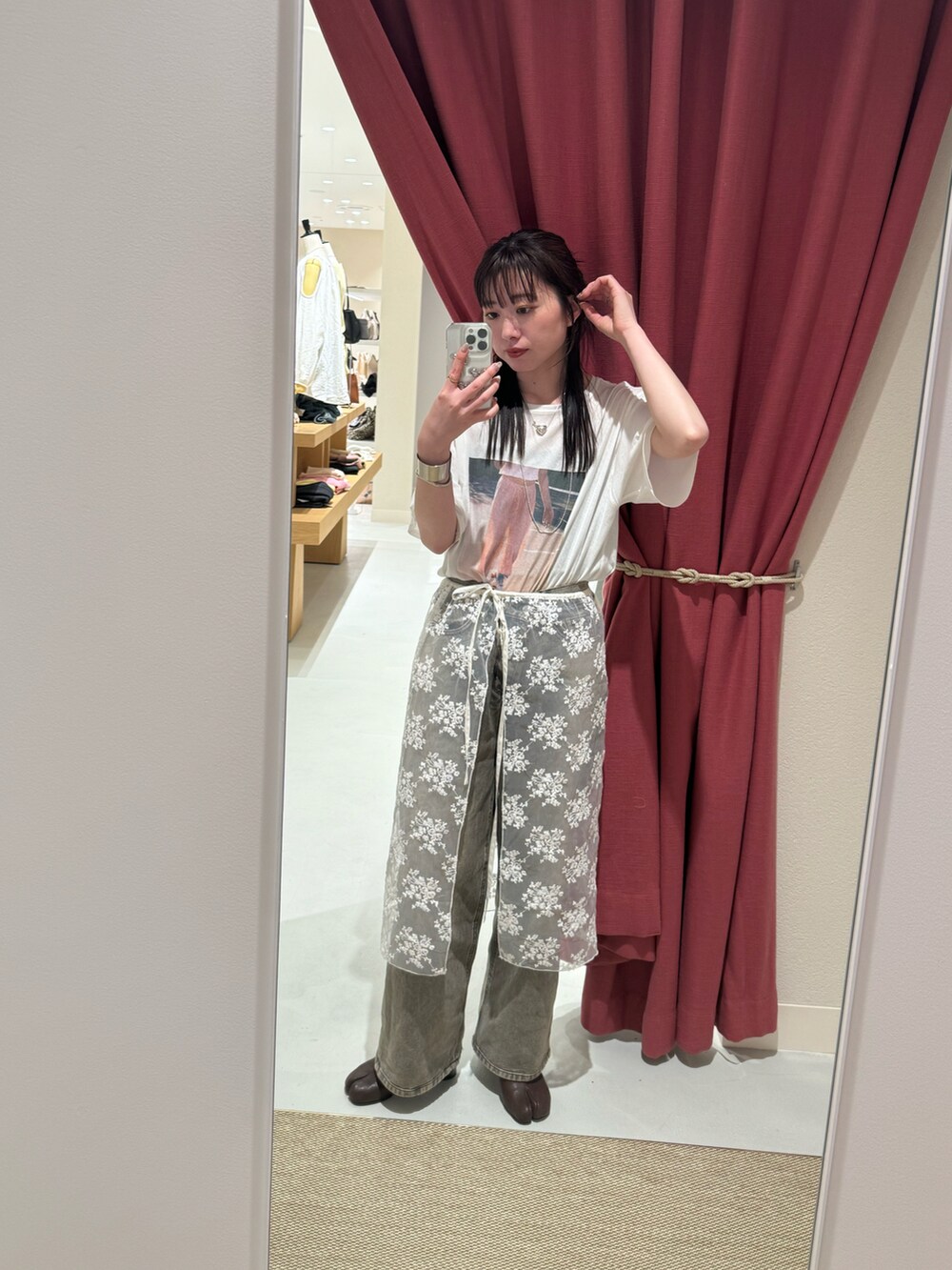 ブルー系のデニムパンツ、ピンク系のTシャツ/カットソー、ホワイト系のスカートを着用したレディースの春コーディネートの2枚目の写真