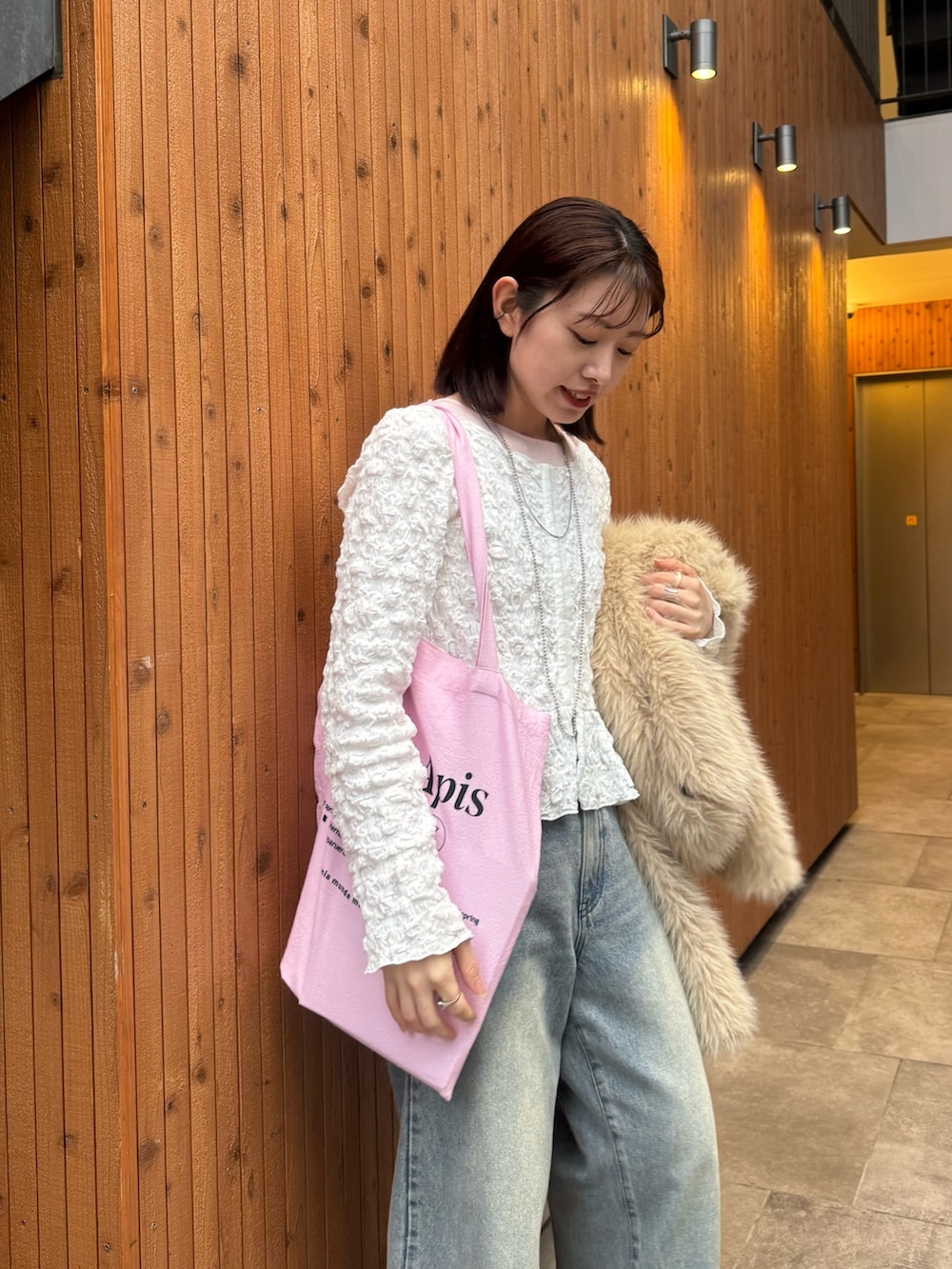 ベージュ系のその他アウター、ピンク系のトートバッグ、ブルー系のデニムパンツを着用したレディースの冬コーディネートの2枚目の写真