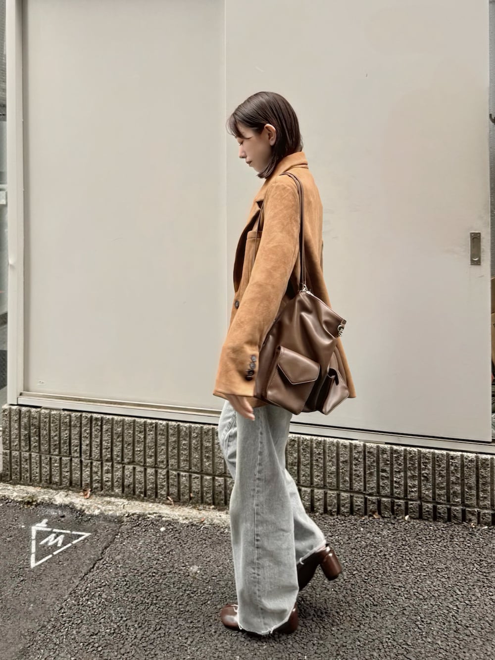 イエロー系のテーラードジャケット、イエロー系のトートバッグ、ブラウン系のブーツを着用したレディースの秋コーディネートの2枚目の写真