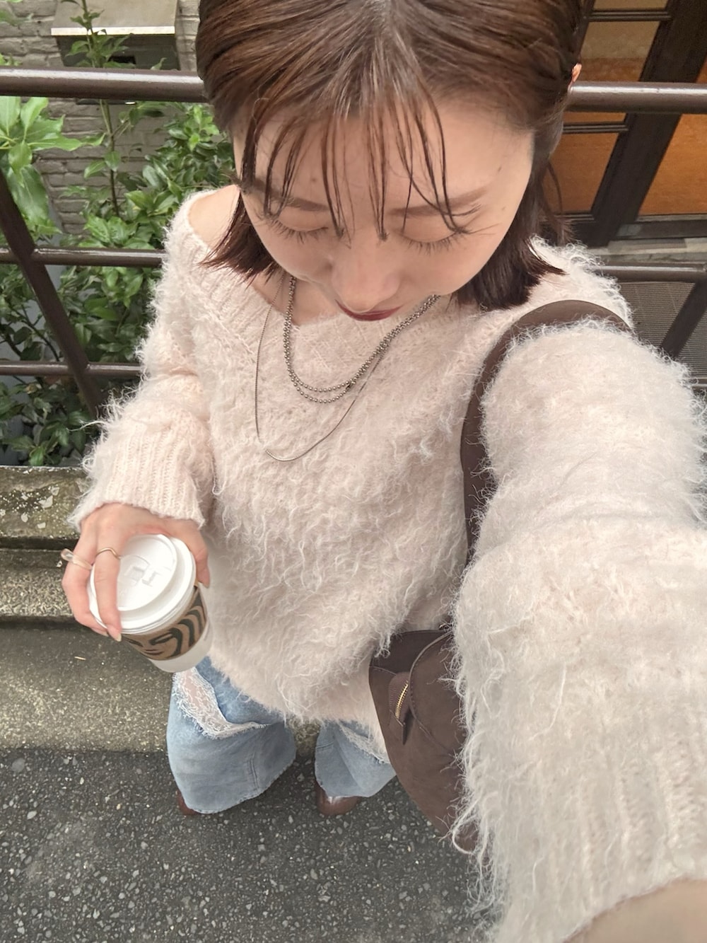 ピンク系のニット/セーター、ブルー系のデニムパンツ、ブラウン系のブーツを着用したレディースの秋コーディネートの4枚目の写真