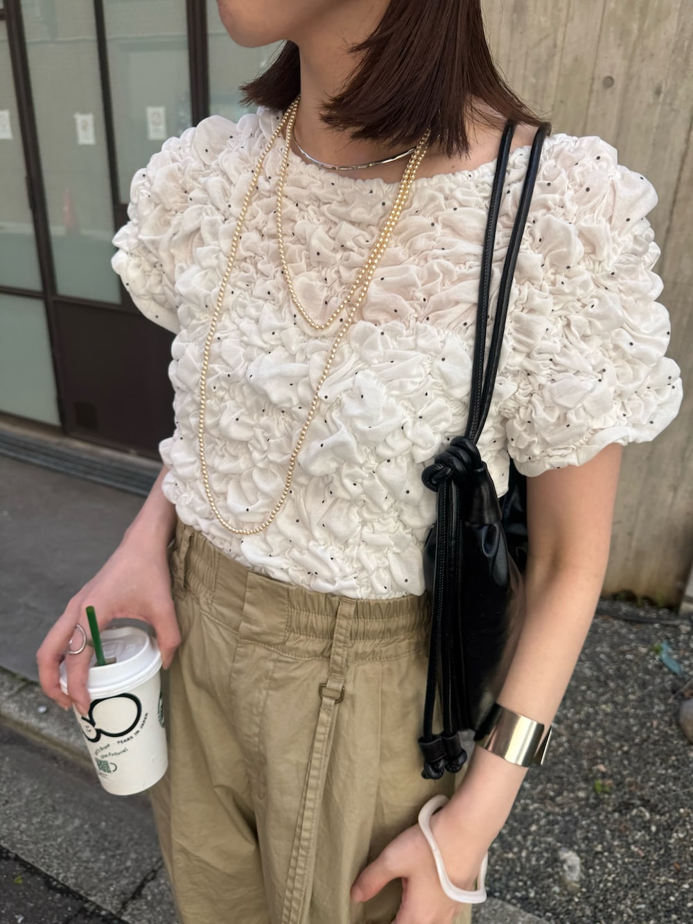 ホワイト系のTシャツ/カットソー、ベージュ系のその他パンツ、ブラック系のパンプスを着用したレディースの春コーディネートの4枚目の写真