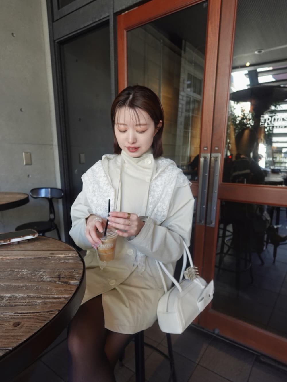 ホワイト系のトレンチコート、イエロー系のブーツを着用したレディースの冬コーディネートの3枚目の写真