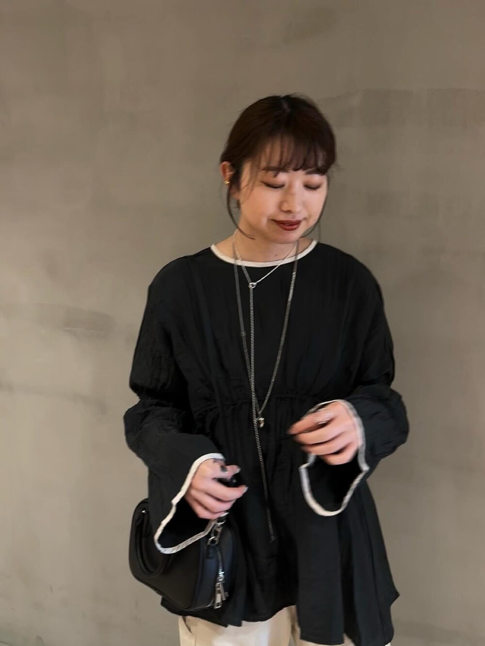 ホワイト系のその他パンツ、ホワイト系のパンプス、ブラック系のシャツ/ブラウスを着用したレディースの冬コーディネートの3枚目の写真