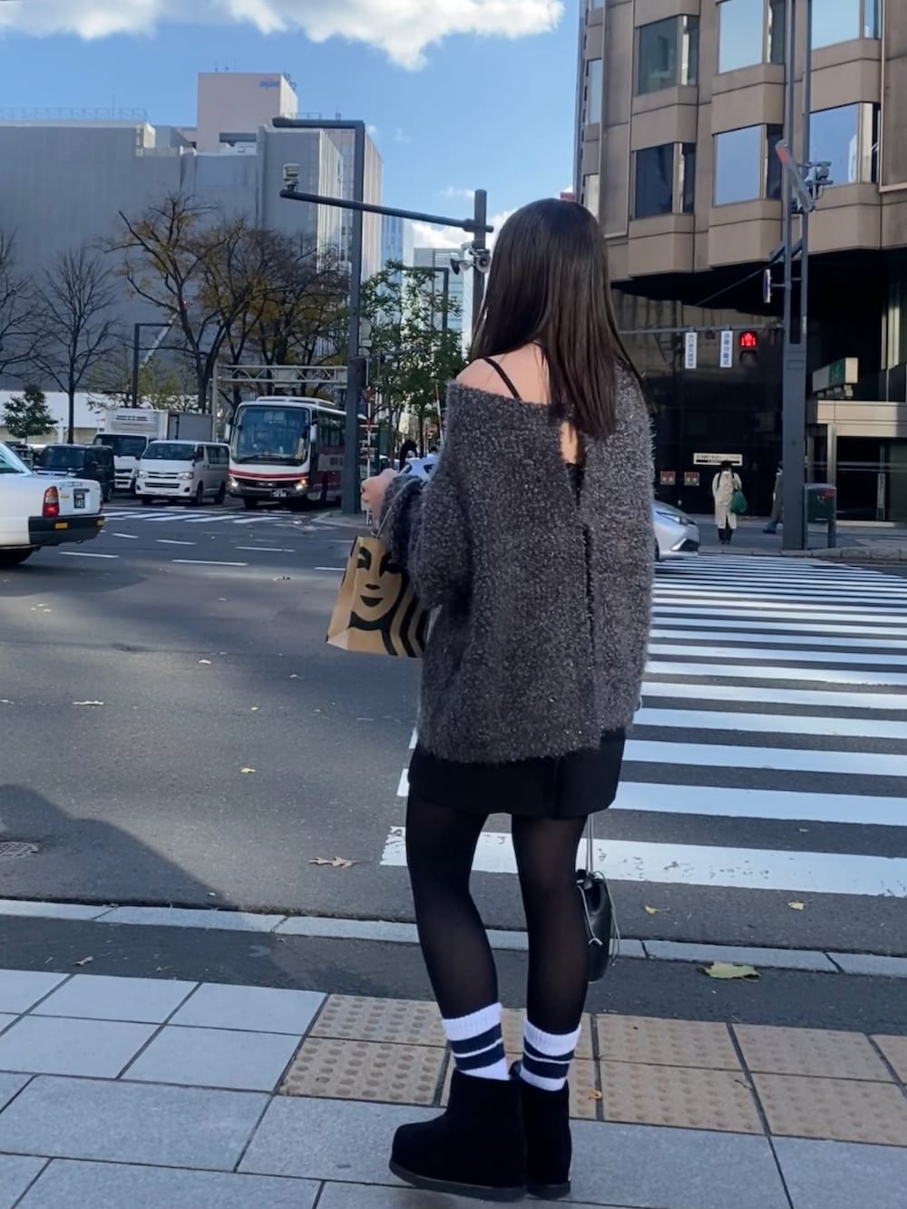 グレー系のカーディガン/ボレロ、ブラック系のスカートを着用したレディースの秋コーディネートの3枚目の写真