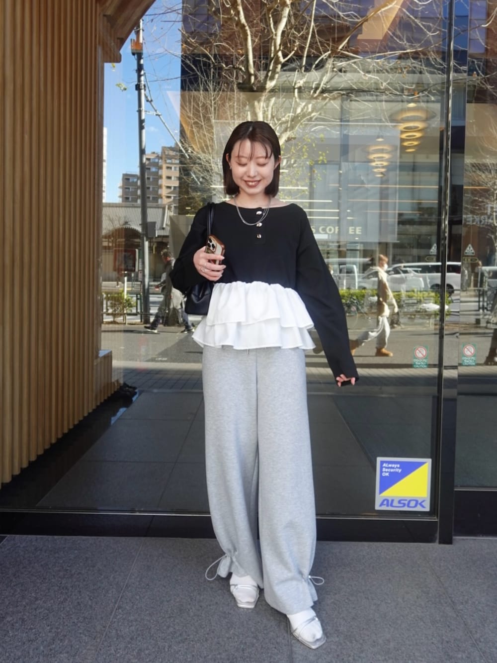 ブラック系のニット/セーター、グレー系のスウェットパンツを着用したレディースの冬コーディネートの5枚目の写真