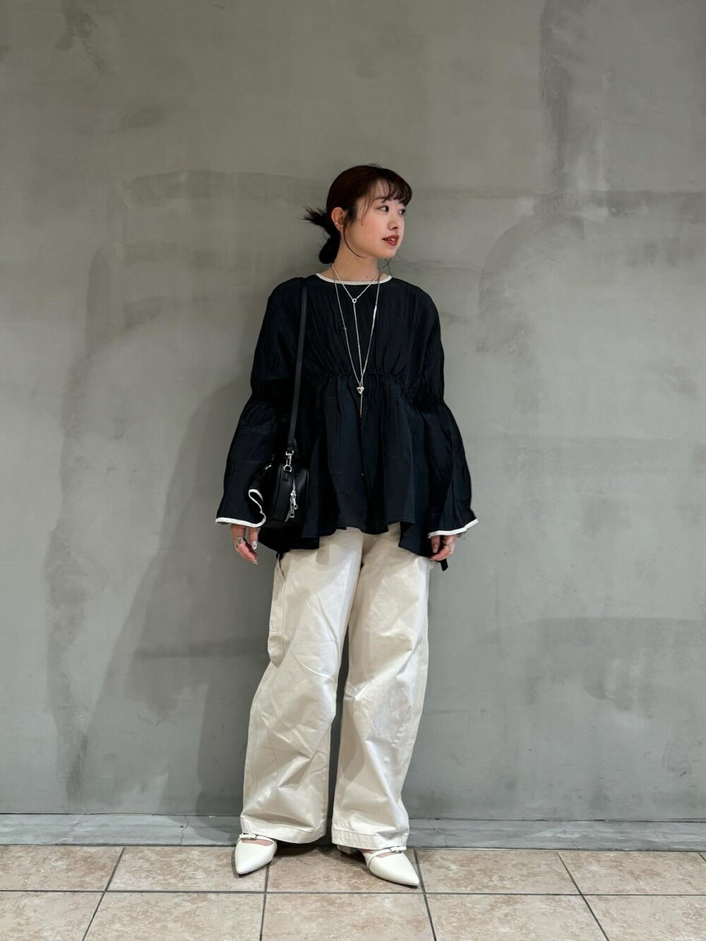 ホワイト系のその他パンツ、ホワイト系のパンプス、ブラック系のシャツ/ブラウスを着用したレディースの冬コーディネートの2枚目の写真