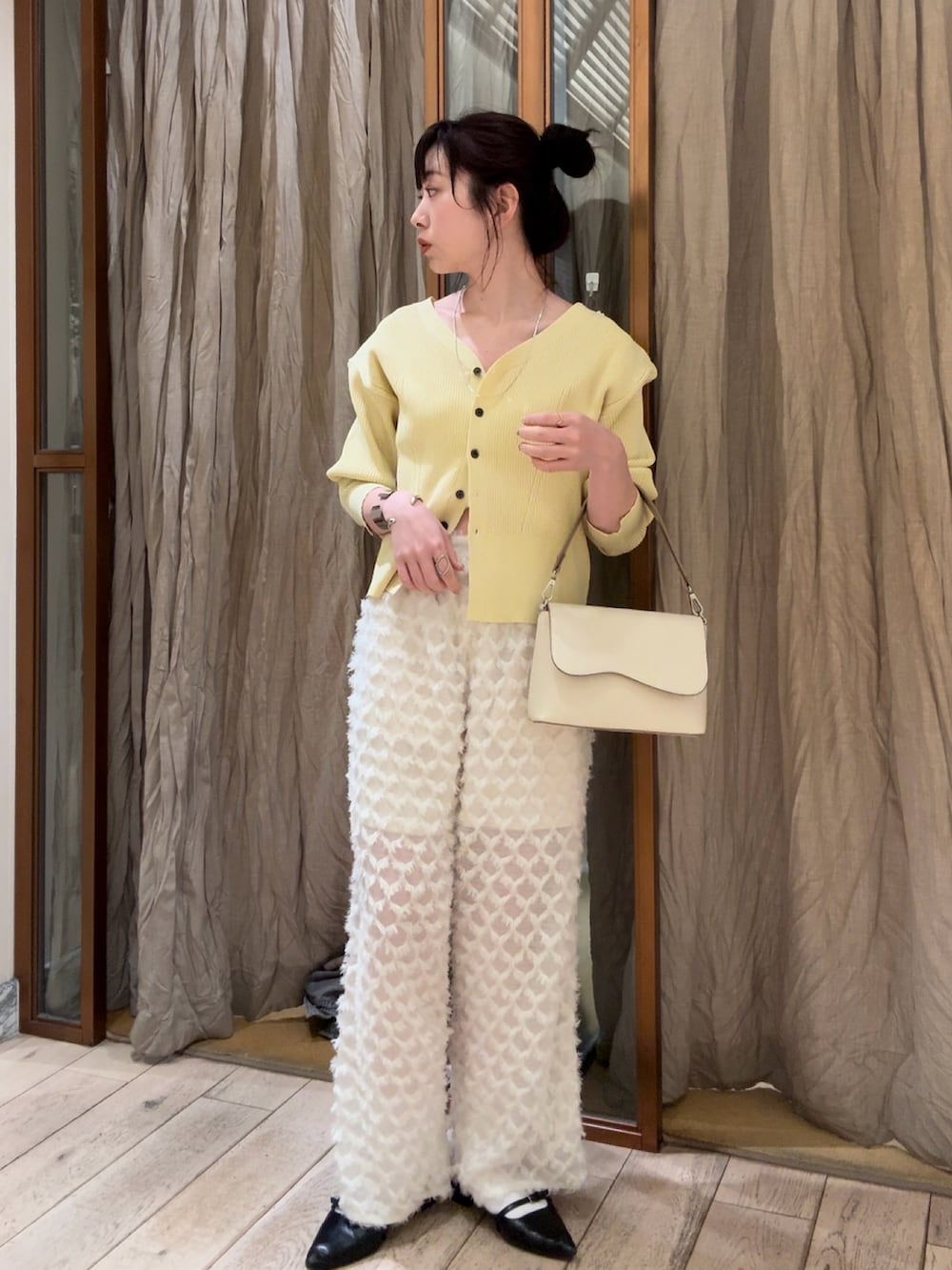 イエロー系のカーディガン/ボレロ、ホワイト系のその他パンツ、ブルー系のデニムパンツを着用したレディースの春コーディネートの2枚目の写真