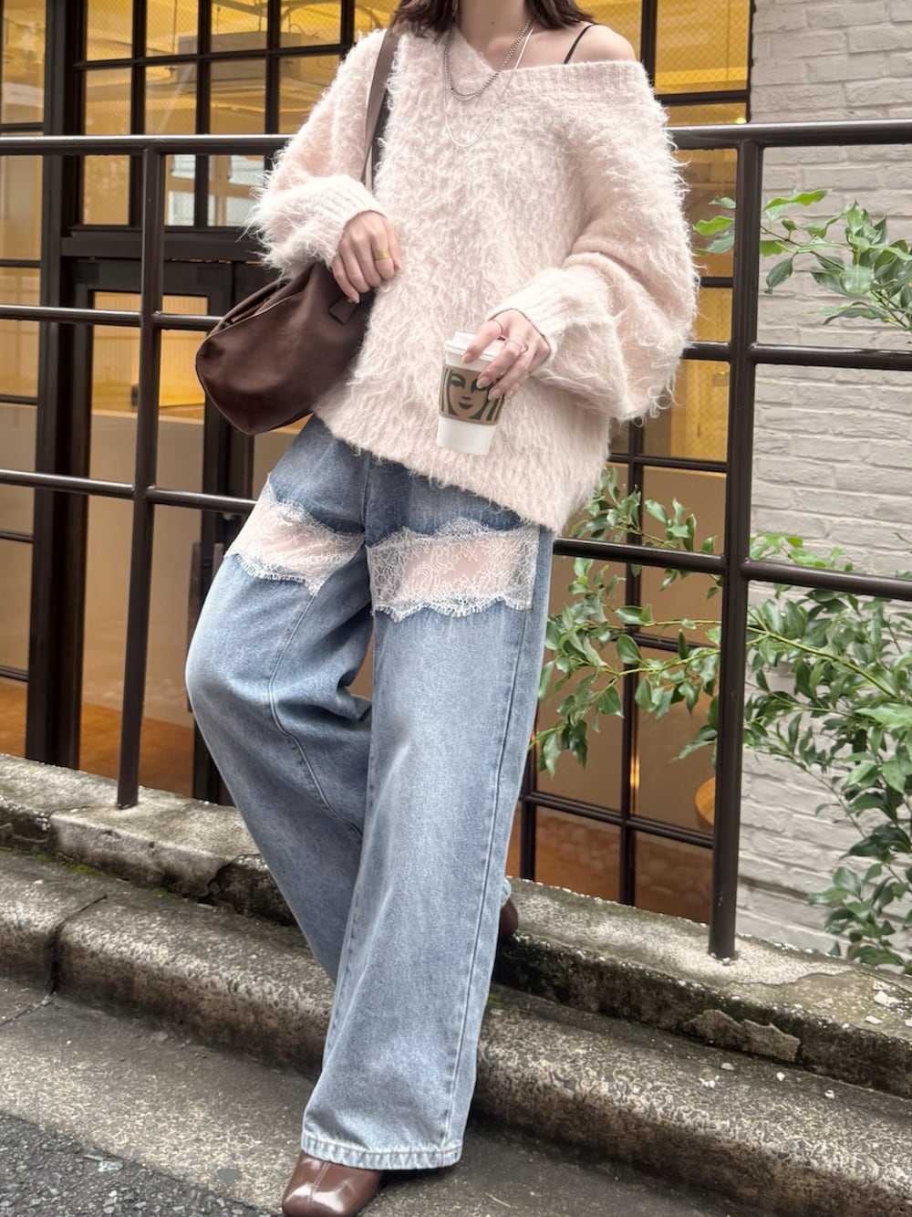 ピンク系のニット/セーター、ブルー系のデニムパンツ、ブラウン系のブーツを着用したレディースの秋コーディネートの2枚目の写真