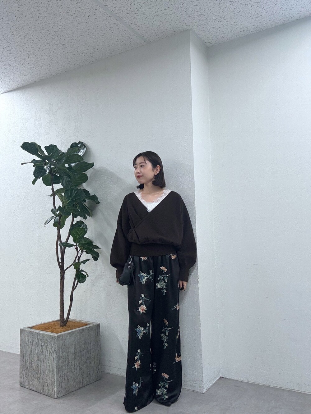 ブラウン系のニット/セーター、ブラック系のその他パンツを着用したレディースの秋コーディネートの2枚目の写真