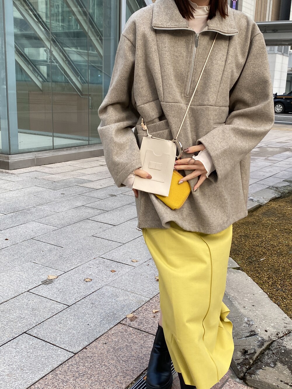 ベージュ系のニット/セーター、グリーン系のスカートを着用したレディースの秋コーディネートの2枚目の写真