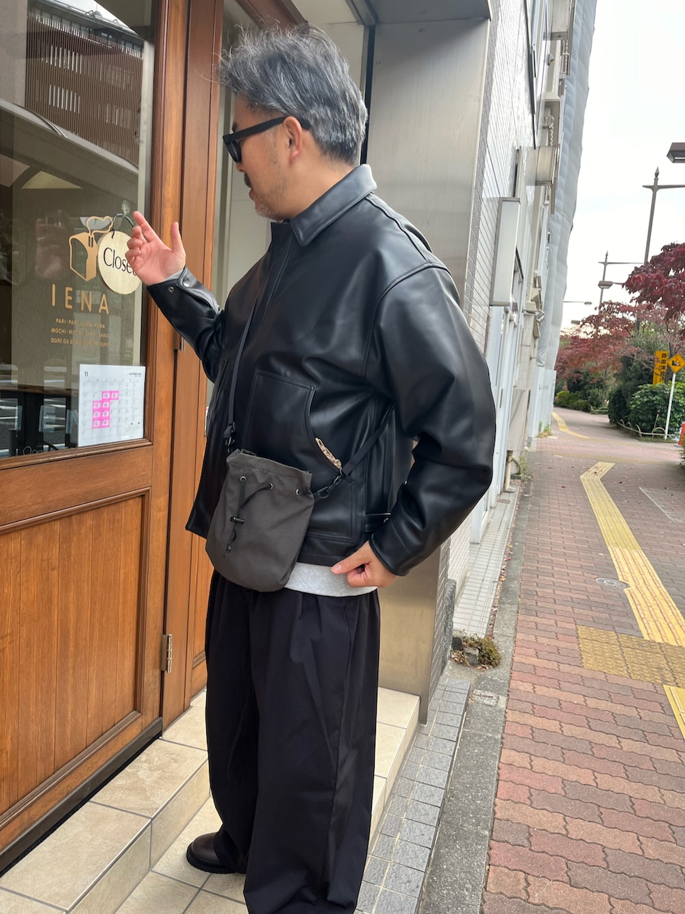 ブラック系のブルゾン、グレー系のボディバッグ/ウエストポーチ、グレー系のスウェットを着用したメンズの秋コーディネートの2枚目の写真