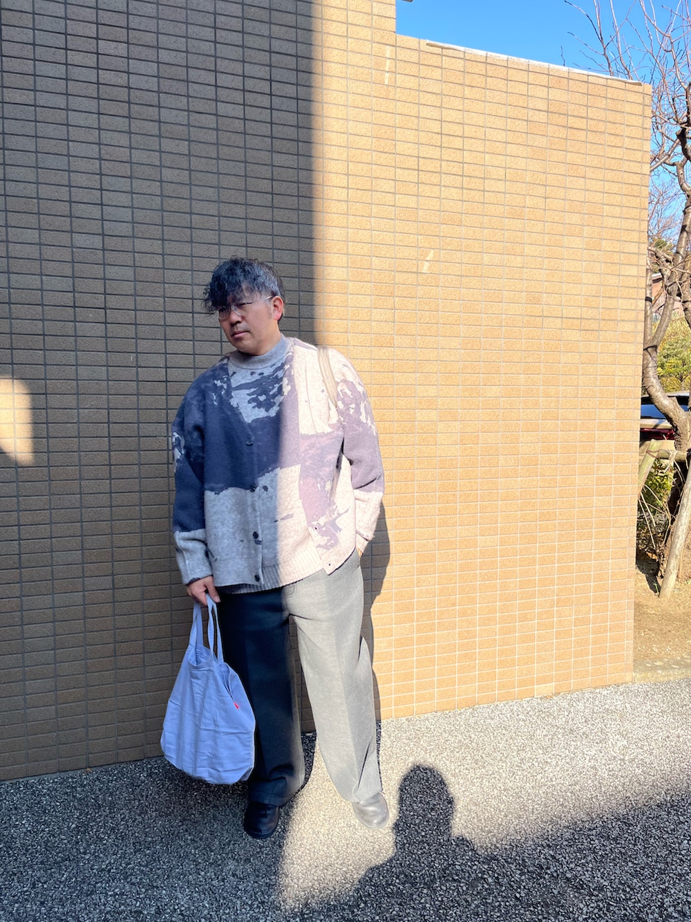 グレー系のニット/セーター、グレー系のカーディガン/ボレロ、ブラック系のスウェットパンツを着用したメンズの冬コーディネートの2枚目の写真