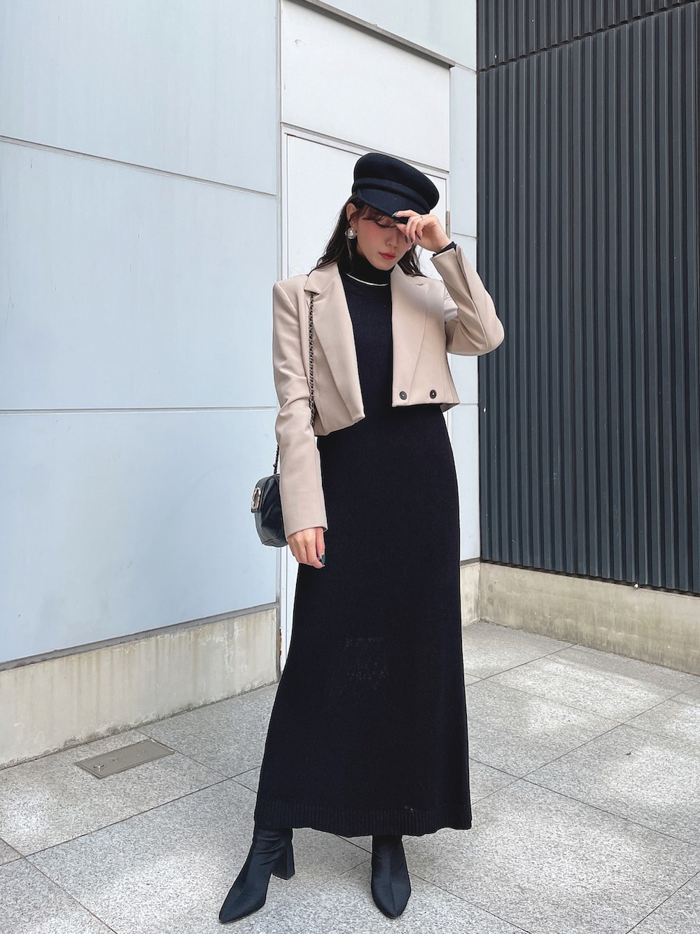 ベージュ系のテーラードジャケット、ブラック系のワンピース、ブラック系のショルダーバッグを着用したレディースの秋コーディネートの2枚目の写真