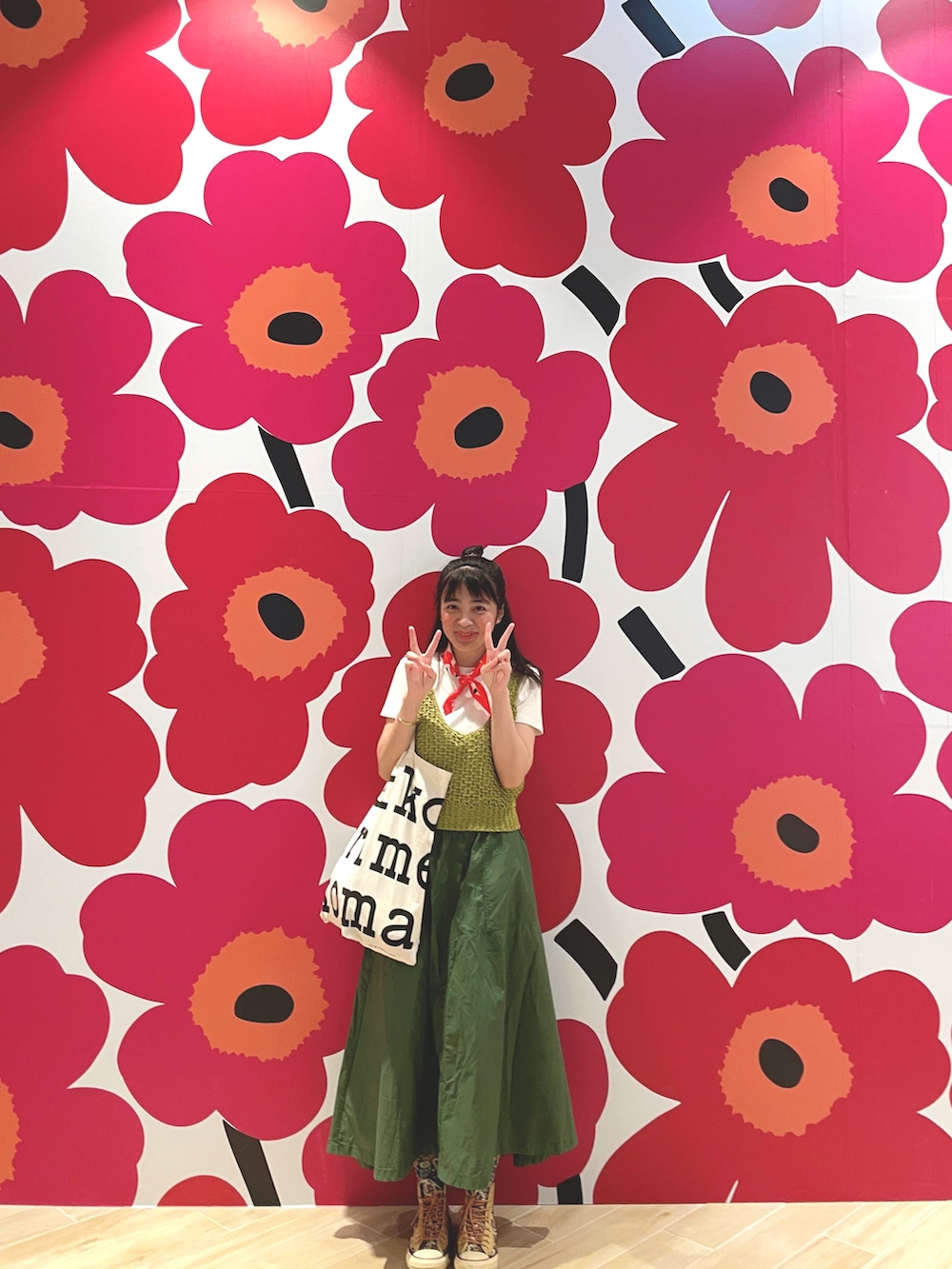 グリーン系のセットアップ、グリーン系のスカート、ホワイト系のシューズを着用したレディースの春コーディネートの2枚目の写真