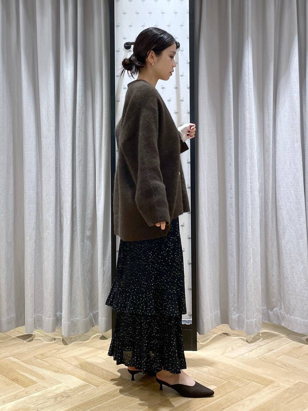 ブラウン系のカーディガン/ボレロ、ホワイト系のTシャツ/カットソー、グレー系のスカートを着用したレディースの秋コーディネートの4枚目の写真