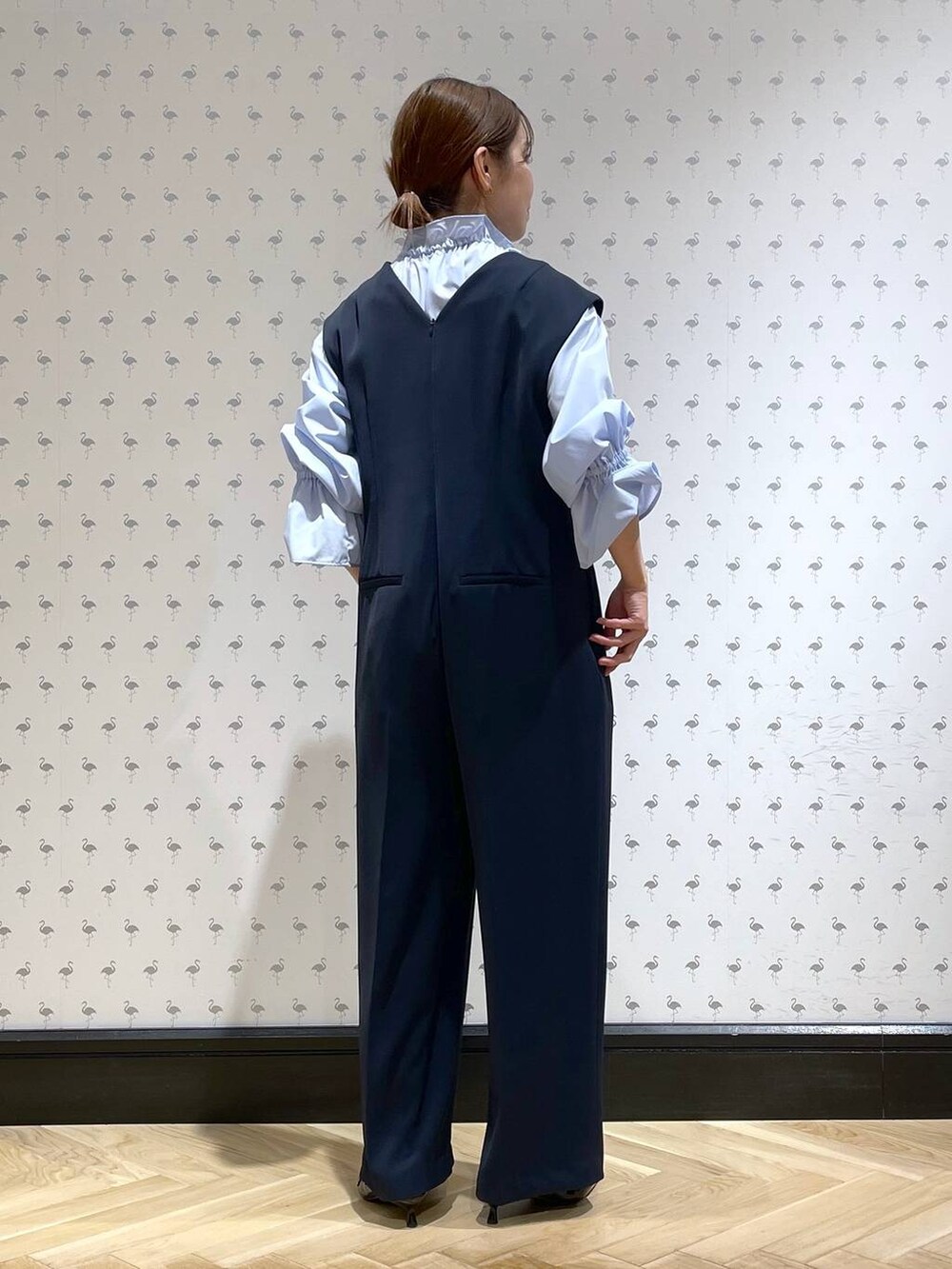 ブラック系のパンプス、ブルー系のサロペット/オーバーオール、ブルー系のシャツ/ブラウスを着用したレディースの冬コーディネートの3枚目の写真