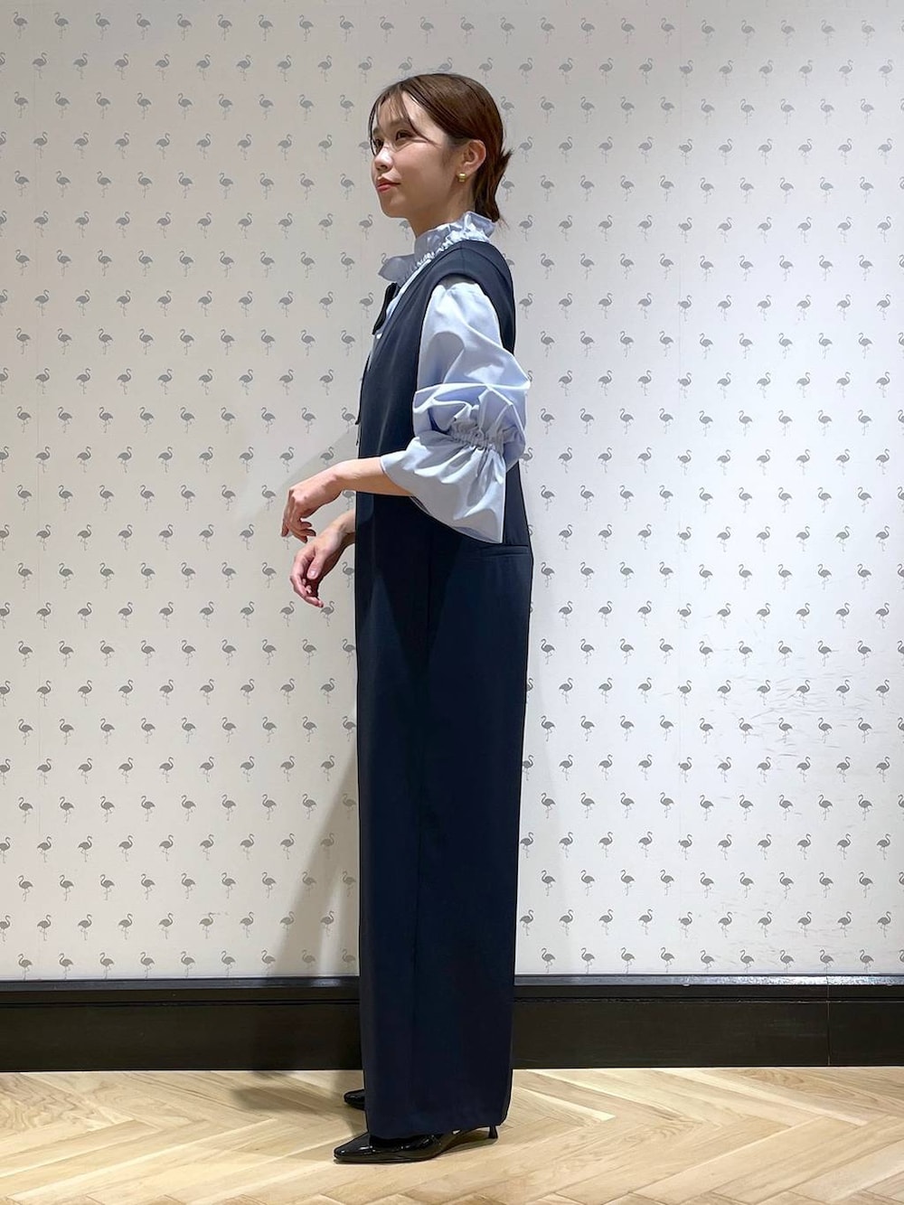 ブラック系のパンプス、ブルー系のサロペット/オーバーオール、ブルー系のシャツ/ブラウスを着用したレディースの冬コーディネートの2枚目の写真