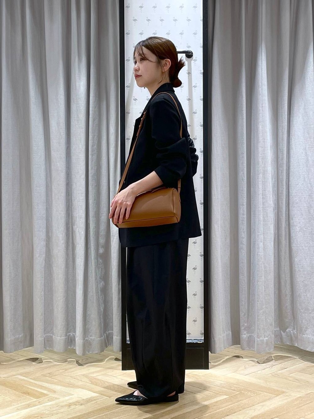 ブラウン系のハンドバッグ、ブラック系のパンプス、ブラック系のその他パンツを着用したレディースの春コーディネートの2枚目の写真