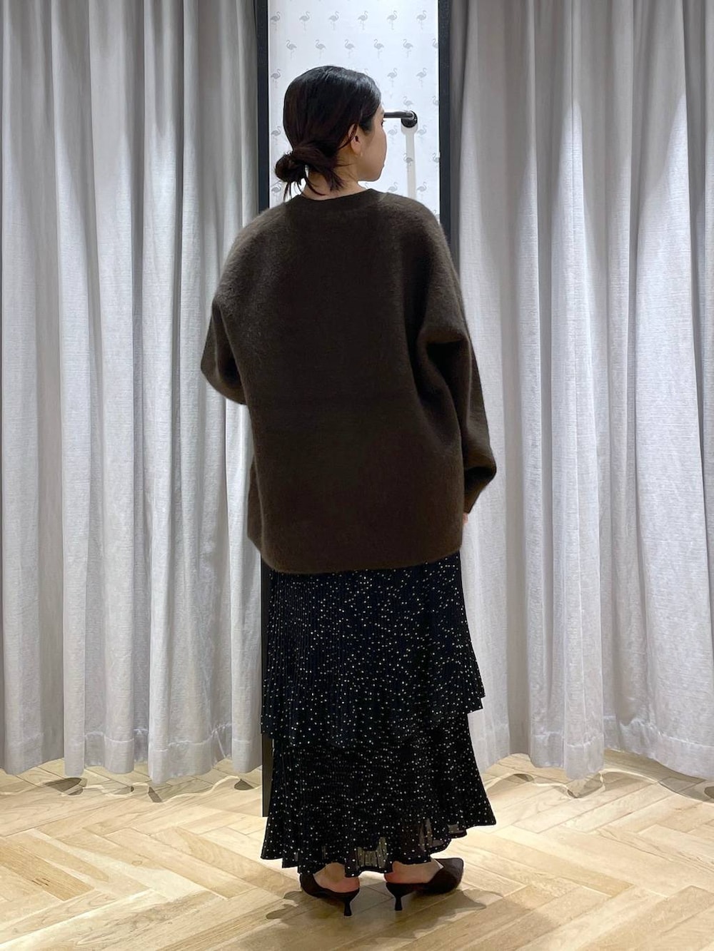 ブラウン系のカーディガン/ボレロ、ホワイト系のTシャツ/カットソー、グレー系のスカートを着用したレディースの秋コーディネートの3枚目の写真
