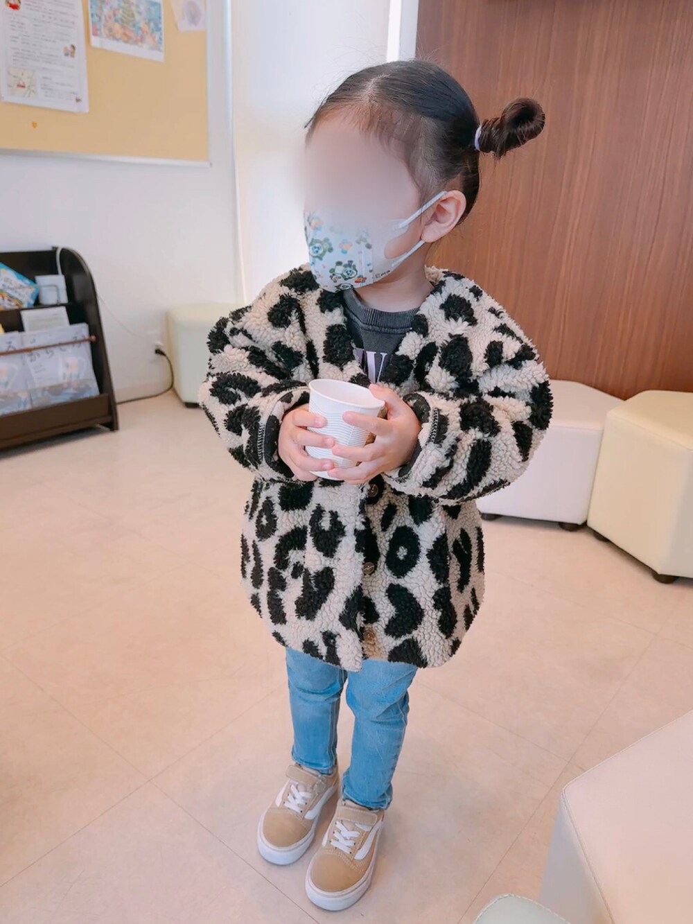 ブラック系のノーカラージャケット、ブルー系のデニムパンツ、ベージュ系のスニーカーを着用したキッズの冬コーディネートの2枚目の写真