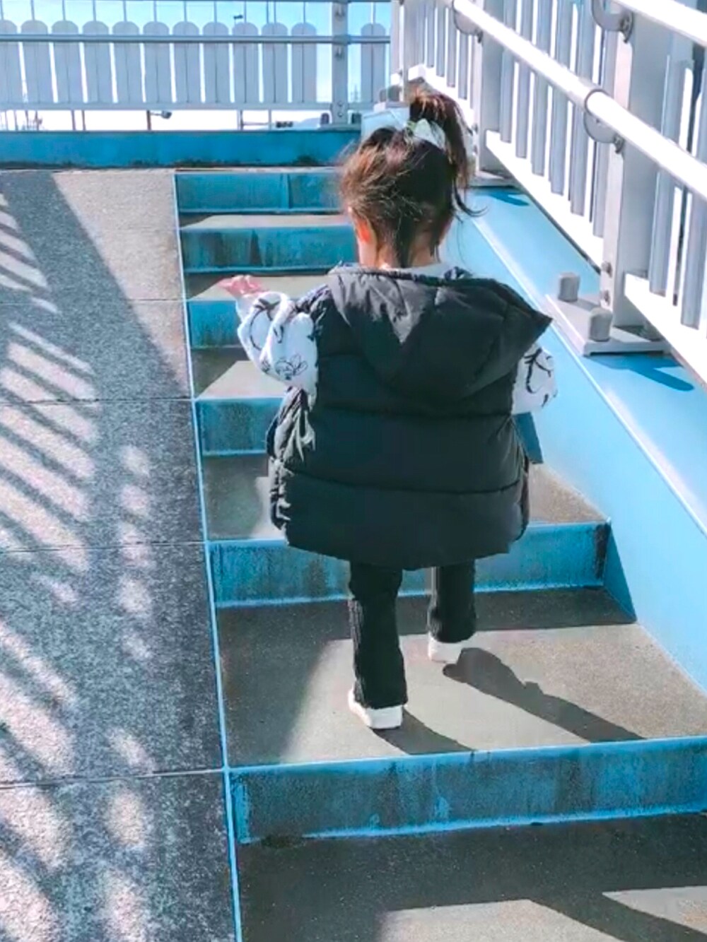 ホワイト系のスウェット、ブラック系のその他パンツ、ブラック系のベストを着用したキッズの冬コーディネートの2枚目の写真