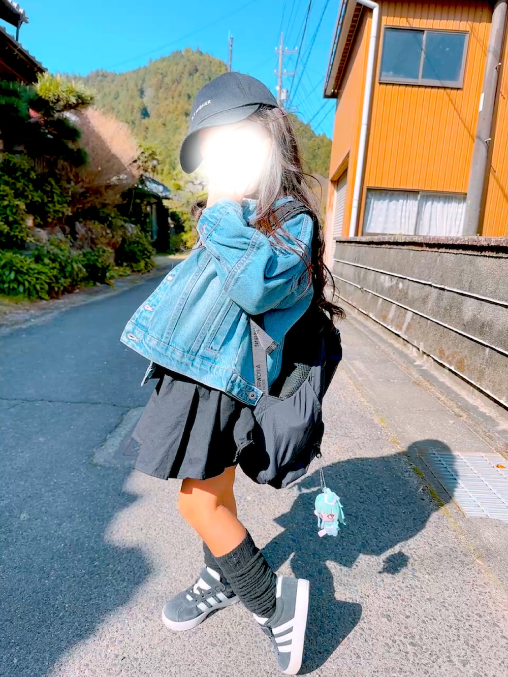 ブルー系のデニムジャケット、ブラック系のスニーカー、オレンジ系のTシャツ/カットソーを着用したキッズの春コーディネートの3枚目の写真