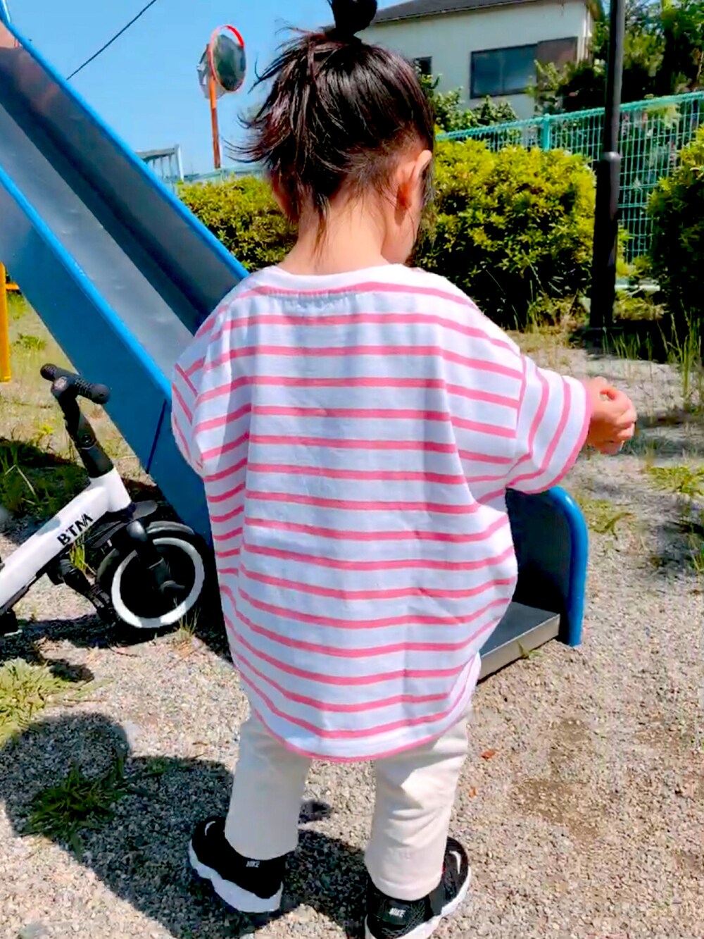 ピンク系のTシャツ/カットソー、ホワイト系のデニムパンツ、ブラック系のスニーカーを着用したキッズの春コーディネートの2枚目の写真