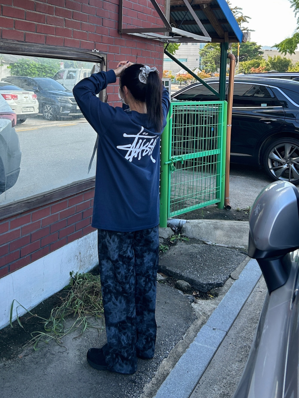 ブルー系のデニムパンツ、ブルー系のTシャツ/カットソー、ブラック系のスニーカーを着用したレディースの夏コーディネートの2枚目の写真