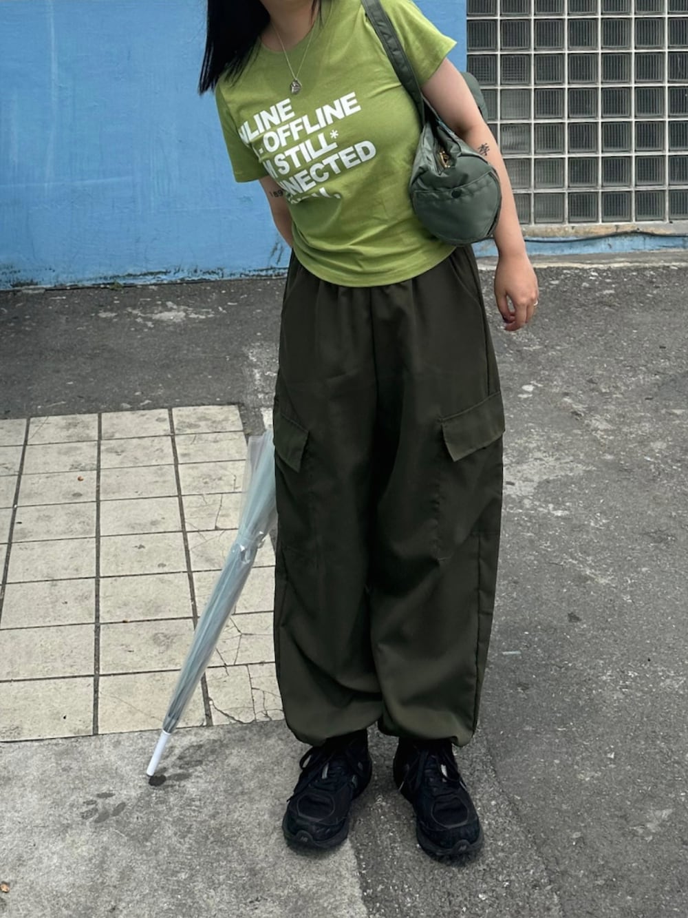 グリーン系のTシャツ/カットソー、グリーン系のカーゴパンツ、ブラック系のスニーカーを着用したレディースの夏コーディネートの3枚目の写真