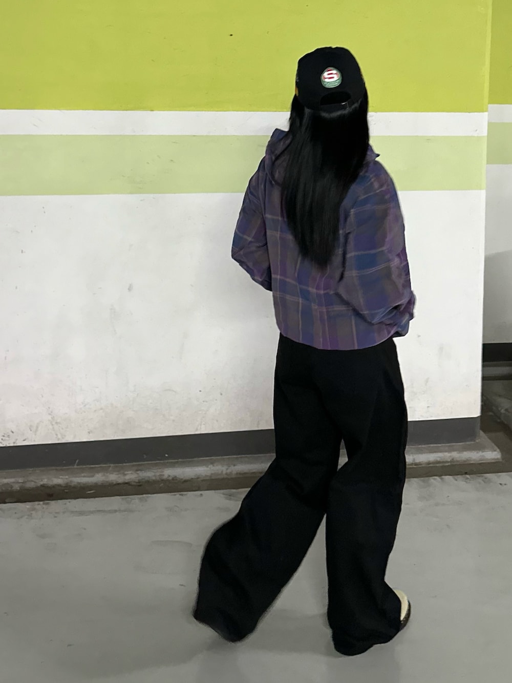 パープル系のパーカー、ブラック系のチノパンツ、グリーン系のブーツを着用したレディースの秋コーディネートの2枚目の写真