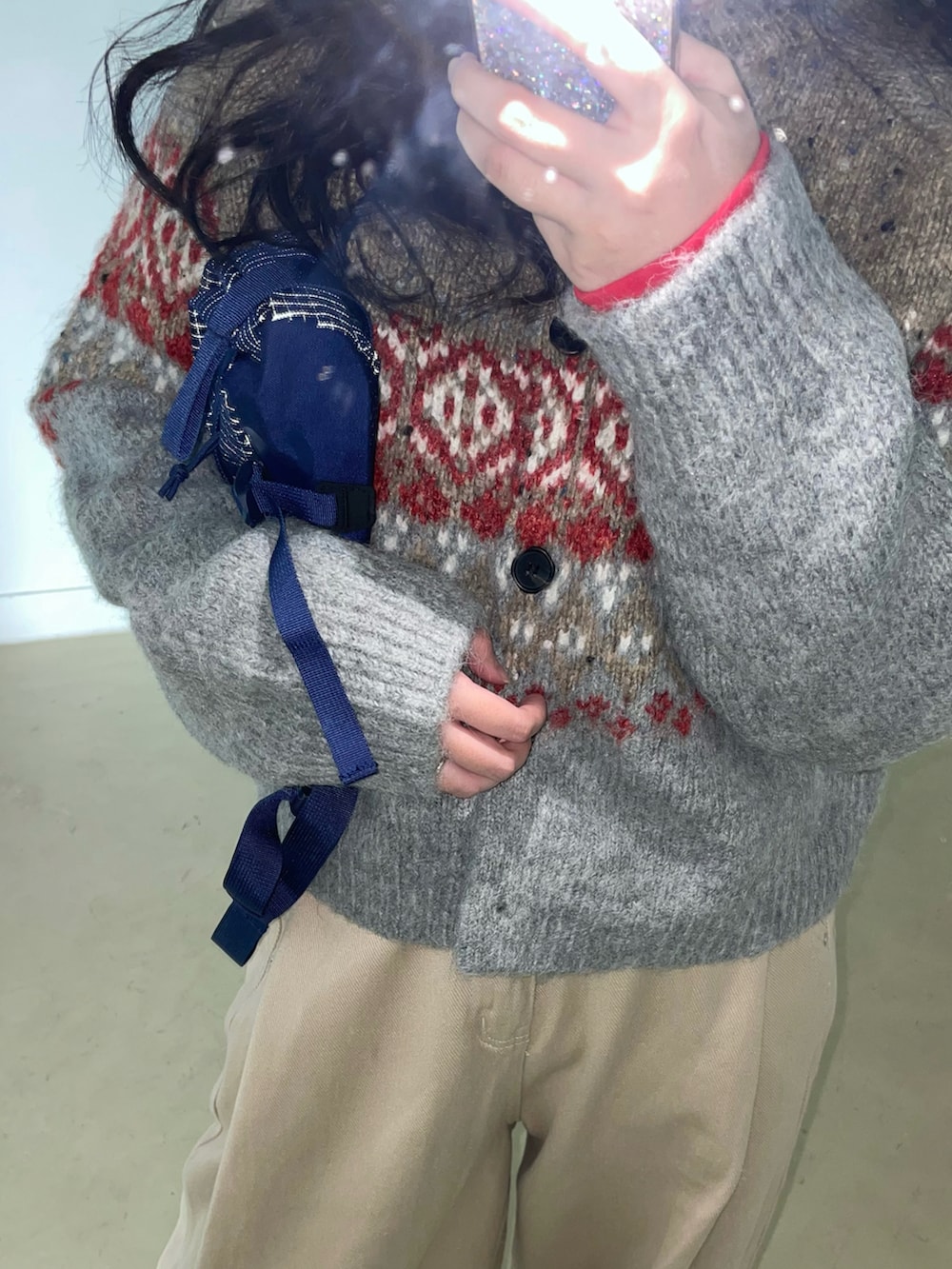 レッド系のスニーカー、ブルー系のボディバッグ/ウエストポーチ、グレー系のカーディガン/ボレロを着用したレディースの秋コーディネートの2枚目の写真