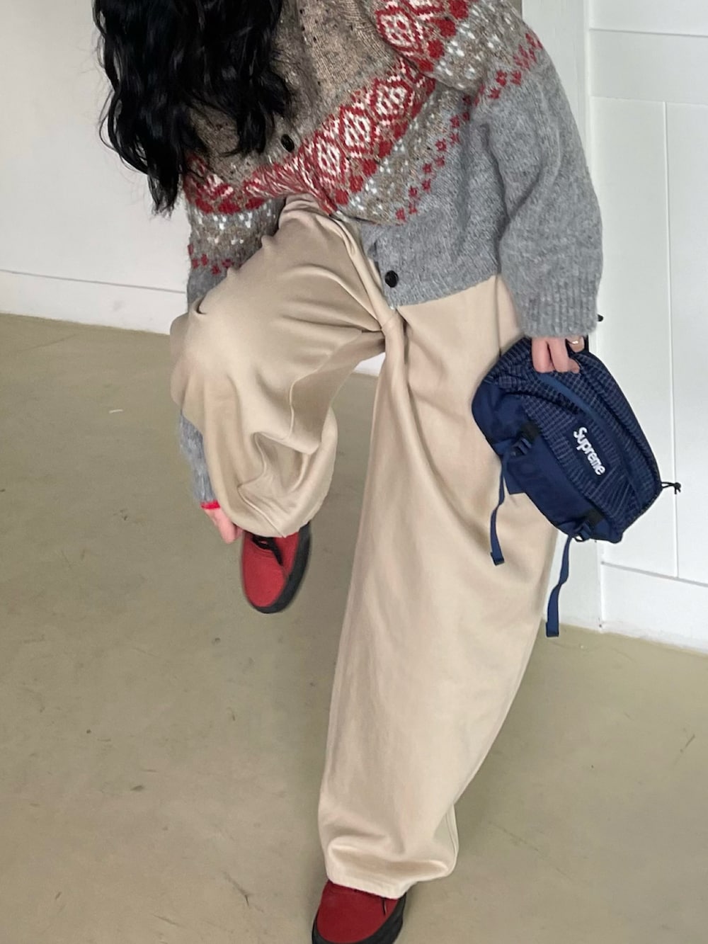 レッド系のスニーカー、ブルー系のボディバッグ/ウエストポーチ、グレー系のカーディガン/ボレロを着用したレディースの秋コーディネートの4枚目の写真