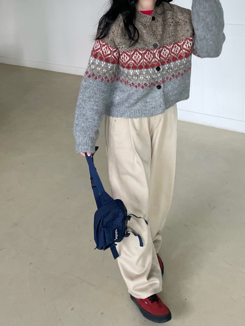 レッド系のスニーカー、ブルー系のボディバッグ/ウエストポーチ、グレー系のカーディガン/ボレロを着用したレディースの秋コーディネートの3枚目の写真