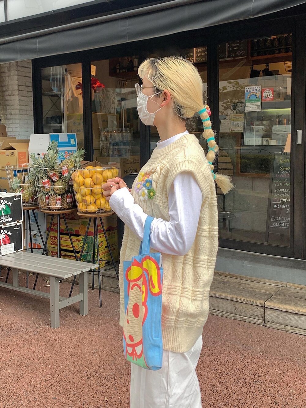 ブルー系のトートバッグ、ホワイト系のデニムパンツを着用したレディースの冬コーディネートの2枚目の写真