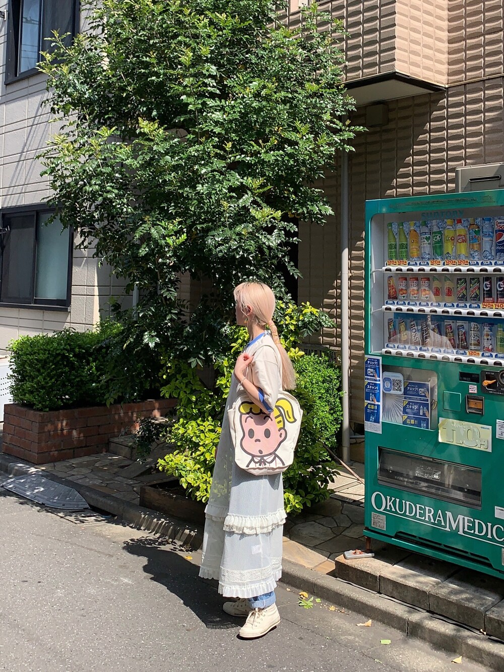 ホワイト系のスカート、ベージュ系のTシャツ/カットソーを着用したレディースの夏コーディネートの2枚目の写真