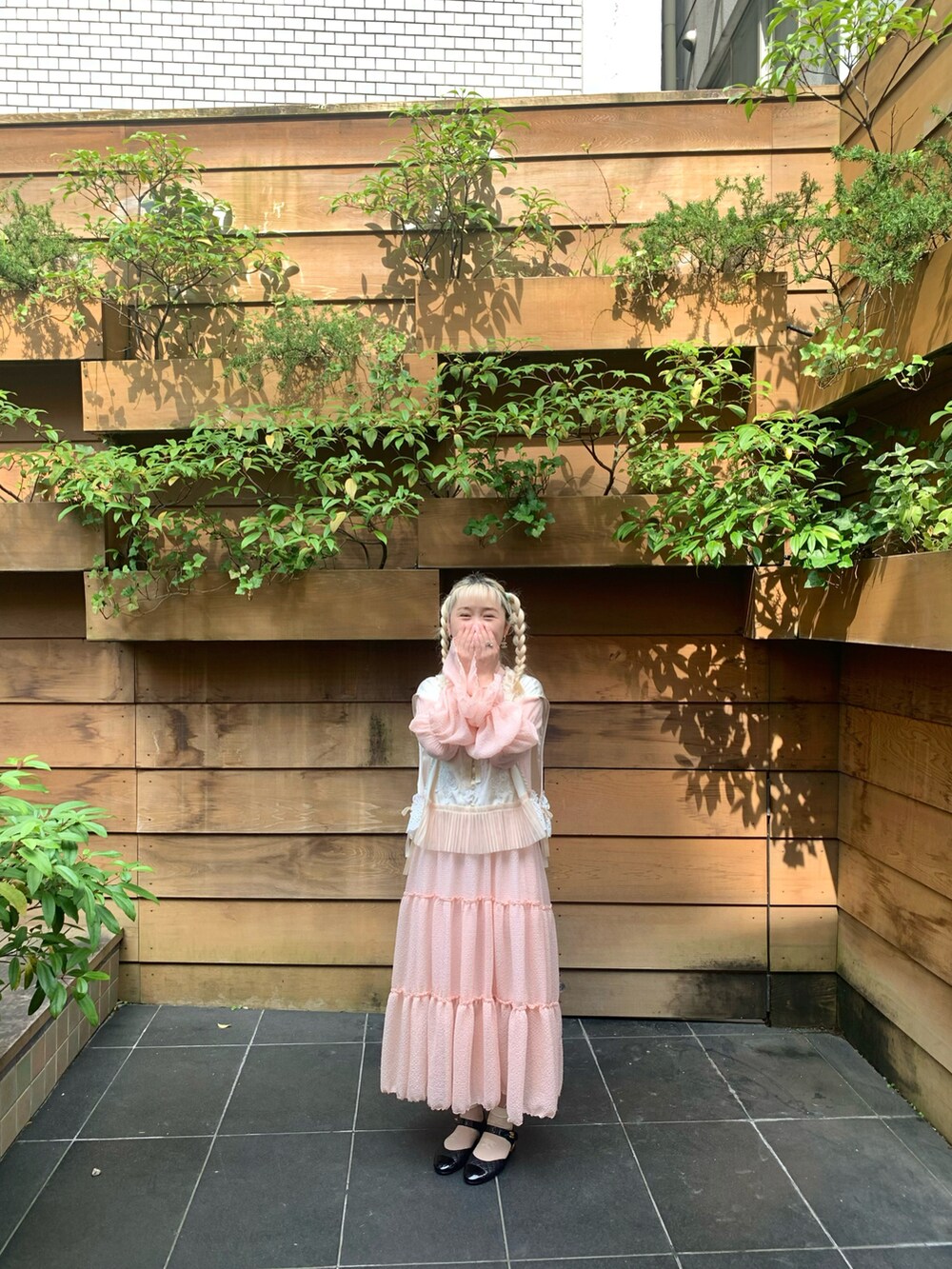 ピンク系のワンピースを着用したレディースの夏コーディネートの2枚目の写真